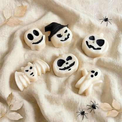 Midnight Coven handmade Halloween candle set by Glowbaltic, six hand-poured white rapeseed wax candles with black details: skull, pumpkin with a black witch's hat, two jack-o'-lanterns, bat and ghost