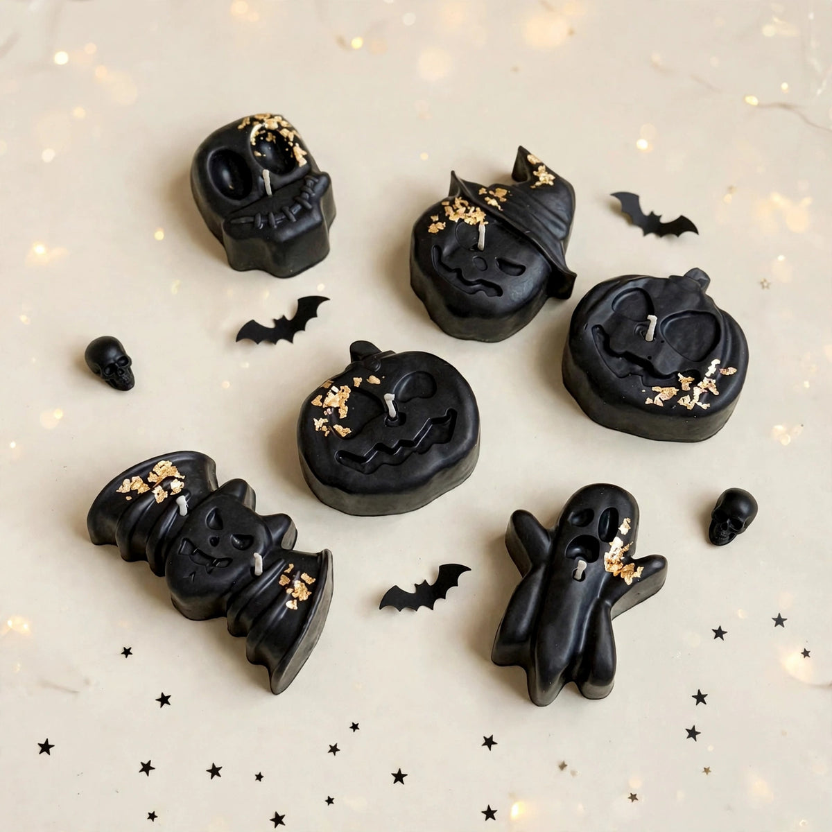 Midnight Coven handmade Halloween candle set by Glowbaltic, six hand-poured black rapeseed wax candles with gold-coloured flakes: skull, witch-hat pumpkin, two jack-o'-lanterns, bat and ghost